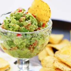 En skål med krämig guacamole, perfekt för ditt nästa guacamole recept. Serveras med tortillachips.