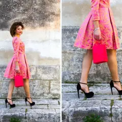 Elegancka kobieta w różowej sukience z złotym wzorem i czarnymi szpilkami. Idealne buty do różowej sukienki na specjalne okazje.