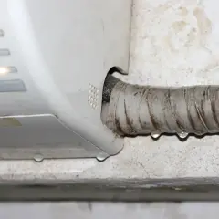 Goteo de agua en la manguera de un aire acondicionado, indicando la necesidad de saber como vaciar el agua del aire acondicionado.