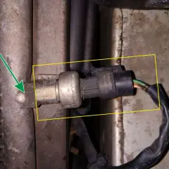 Czujnik temperatury w Renault Kangoo znajduje się przy chłodnicy klimatyzacji. Strzałka wskazuje jego lokalizację.