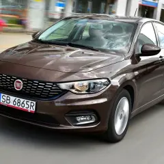 Brązowy fiat tipo sedan w ruchu miejskim.