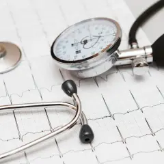 Stetoskop i ciśnieniomierz na tle EKG. Dbanie o serce, jak przyjmowanie leku Valsacor, jest kluczowe.