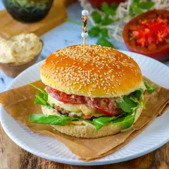 Un délicieux pain burger maison garni de viande, fromage fondant, tomates et roquette fraîche. Un vrai régal !