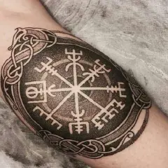 Tatuaż na ramieniu: kompas wikingów, symbol Vegvisir, otoczony skomplikowanymi nordyckimi wzorami.