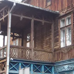Drewniana willa z werandą, ozdobnymi balustradami i okiennicami, część szlaku świdermajerów.