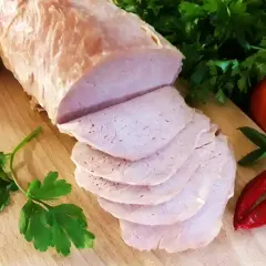 Pokrojony schab gotowany 2 razy po 10 minut, podany z pomidorami, papryczkami chili i natką pietruszki na desce.