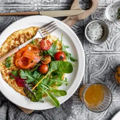 Pyszny omlet na słono z łososiem, pomidorkami i rukolą. Idealny na śniadanie lub lekki lunch.