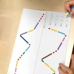 Dziecko rozwiązuje zadanie matematyczne z koralikami, które przypominają ścieżkę żółwia. Programowanie przez zabawę.