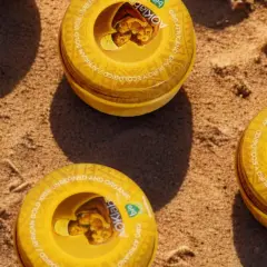Latas de manteca de karité para el pelo, oro africano 100% puro y ecológico, sobre arena.