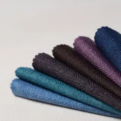 Échantillons de tissus aux teintes profondes, évoquant la richesse des 15 fibres naturelles. Bleu, turquoise, violet, marron.