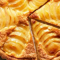 Tarta de peras y almendras dorada y jugosa, con finas láminas de pera y una base crujiente.