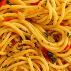 Nahaufnahme von Spaghetti Aglio e Olio, dem originalen Gericht mit Knoblauch, Chili und Petersilie.