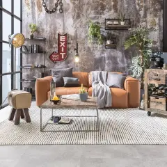 Gemütliches Wohnzimmer im **retro stil** mit cognacfarbenem Sofa, Holztisch und rustikalem Weinregal.