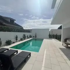 Nowoczesny basen z leżakami i kaktusami, idealny na tanie domy w Portugalii nad morzem.