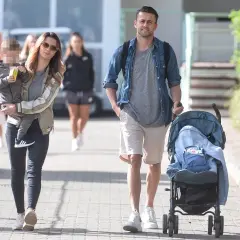 Para spacerowa: kobieta z dzieckiem na rękach i mężczyzna pchający wózek. Czy Fabiański ma dzieci? Tak, wygląda na to, że tak.