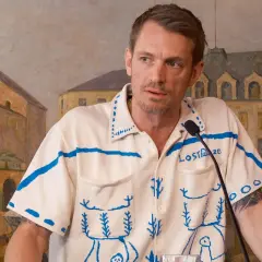 Joel Kinnaman i ny serie, klädd i en vit tröja med blått mönster och texten "Lost Maze".
