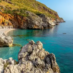 Una caletta nascosta con acque cristalline e rocce imponenti, un gioiello tra le **best beaches in Sicily**.