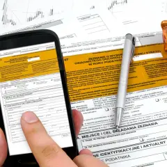 Smartfon z formularzem PIT-37 i złotą świnką skarbonką. Instrukcja jak rozliczyć PIT 37.