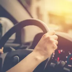 Ręce na kierownicy, słońce na desce rozdzielczej. Pamiętaj o OC, bo kara za brak OC może być dotkliwa.