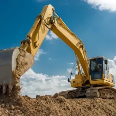Żółta koparka pracuje na budowie. Zastanawiasz się, ile zarabia operator koparki w Niemczech?