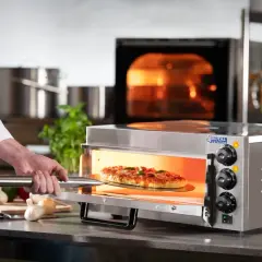 Szef kuchni wyjmuje pizzę z rozgrzanego piekarnika. Dowiedz się, jak ustawić piekarnik na pizzę, by uzyskać idealny efekt.
