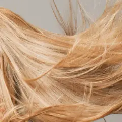 Mujer rubia con el pelo largo y suelto que parece que el pelo se aclara con el sol.