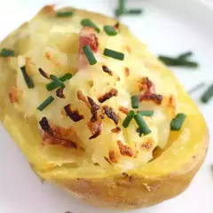 Patatas al horno con queso y bacon, gratinadas y espolvoreadas con cebollino fresco. ¡Un bocado delicioso!