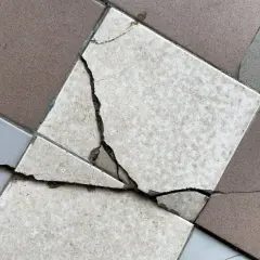 Un carreau de carrelage est brisé, montrant la nécessité de le changer.
