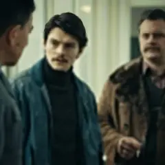 Trzech mężczyzn w rozmowie, jeden w mundurze. Atmosfera napięcia, jak w filmie "Hiacynt".