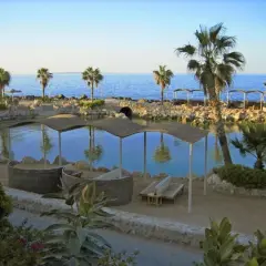 Relaks przy wodzie w Albatros Citadel Sahl Hasheesh. Palmy, kamieniste brzegi i zaciszne miejsca do odpoczynku.