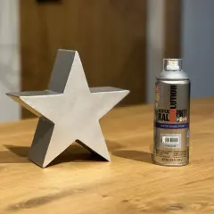 Srebrna gwiazda obok puszki z gwasz farby w sprayu.