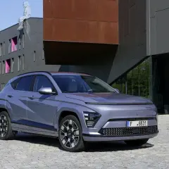 Le plus petit SUV, un véhicule gris moderne, se gare devant un bâtiment architectural audacieux.