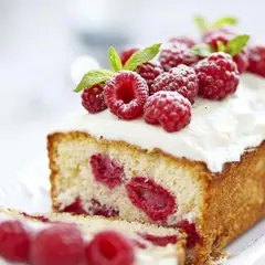 Un délicieux framboisier gateau, garni de framboises fraîches et de crème fouettée, prêt à être dégusté.
