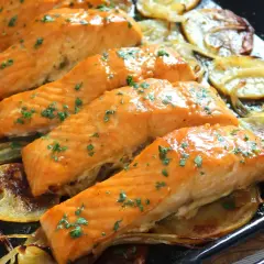 Filetes de salmón jugoso al horno con patatas y cebolla asadas.