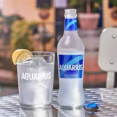 Un vaso y una botella de Aquarius con limón y hielo. Es bueno el Aquarius para los niños, ideal para hidratarse.