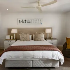 Luxurious hotel bedding layers, featuring crisp white sheets, decorative pillows, and a warm throw, invite a restful night's sleep.
