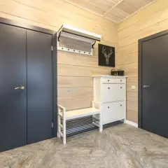 Stylowa aranżacja mieszkania 30m2: ciemne drzwi, biała szafka na buty z ławką i wieszak.