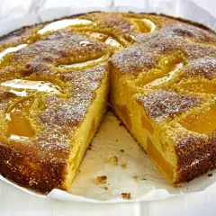 Szybkie ciasto z twarogiem i brzoskwiniami, posypane cukrem pudrem. Idealne na deser, gdy masz ochotę na coś pysznego.