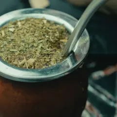 Ein traditioneller Mate-Tee-Becher aus Leder, gefüllt mit getrockneten Mate-Blättern und einer Metall-Bombilla.