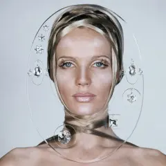 Mujer con peinado elaborado y joyas colgantes, un estilo que aporta brillo para el pelo.