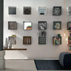 Moderna parete con mensole quadrate, alcune decorate, altre contenenti libri e oggetti, per arredare con stile.