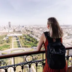 Kobieta z plecakiem podziwia panoramę Paryża. To idealny czwartek po francusku, pełen słońca i widoków.