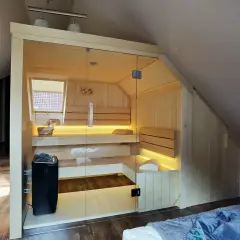 Nowoczesna sauna w domu, z przeszklonymi drzwiami i nastrojowym oświetleniem. Idealne miejsce na relaks po długim dniu.