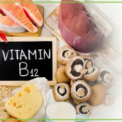 Tablica z napisem "Witamina B12" otoczona produktami bogatymi w tę witaminę: łosoś, wątróbka, mięso, krewetki, ser, jajka, grzyby, płatki owsiane.