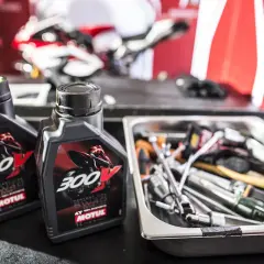 Dwie butelki oleju Motul 300V obok narzędzi. Czy Motul jest lepszy do motocykli sportowych?