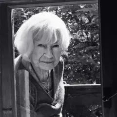 Portret starszej kobiety z siwymi włosami, patrzącej przez okno. Może to być inspiracja do filmów Doroty Kędzierzawskiej.