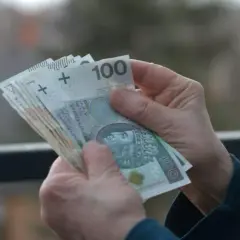 Dłonie liczą banknoty 100 zł. Może to być wynagrodzenie, oszczędności lub przychód z działalności nierejestrowanej.
