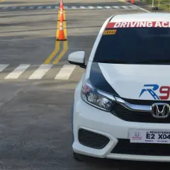 Samochód z napisem "Driving Academy" na placu manewrowym. Może to być miejsce, gdzie można zdobyć prawo jazdy od 16 lat.
