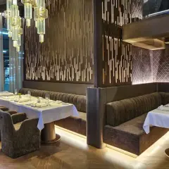 Eleganckie wnętrze restauracji w Poznaniu, z białymi obrusami i nowoczesnym designem. Idealne miejsce na odkrycie nowych restauracji w Poznaniu.