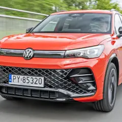Nowy Tiguan w jaskrawym kolorze jedzie po drodze.
